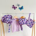 Baby Swimwear Set in pastel purple butterfly print, includes UPF 50+ long sleeve rashie with front zipper, adjustable swim nappy, sun hat with toggles, and matching wet bag.