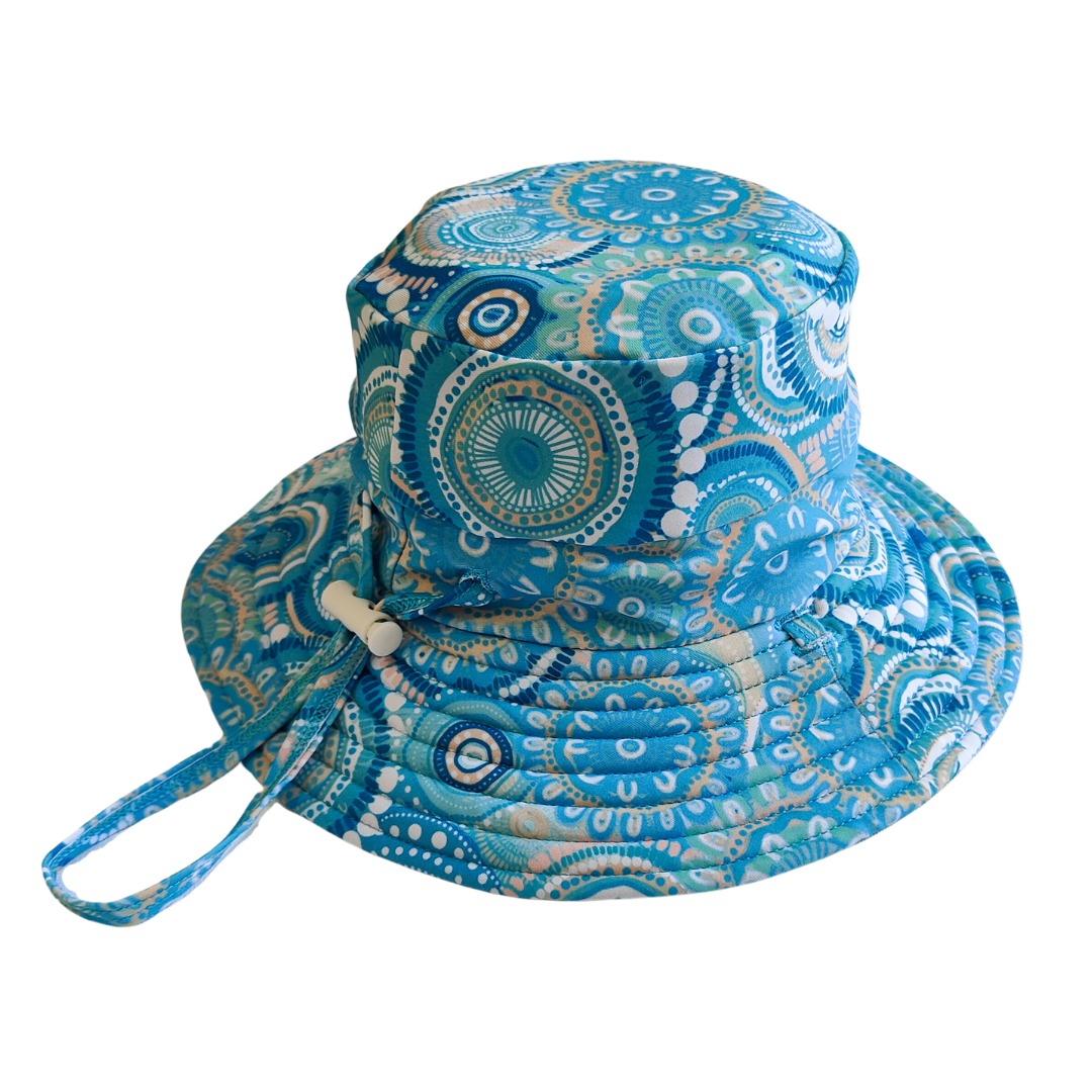 LITTLE E & CO – kids swim hat, a turquoise blue with a colourful contemporary indigenous print. Made with UPF 50+ sun protection fabric. The swim hat features adjustable toggles.