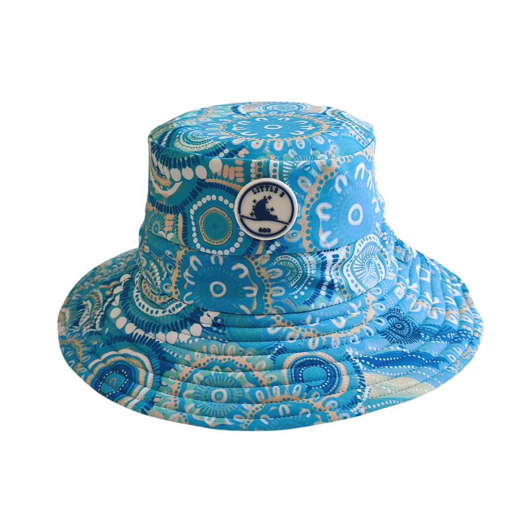 Kids swim hat in turquoise blue with a colourful Indigenous print, featuring adjustable toggles and UPF 50+ sun protection.