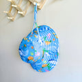 Kids swim hat in blue ocean print with whales, turtles, fish, and coral, made with UPF 50+ sun protection fabric and adjustable toggles for a secure fit.