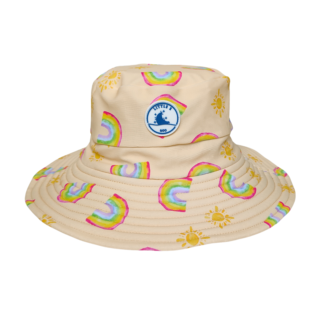 Kids swim hat in pale yellow with rainbow and sun print, featuring adjustable toggles and UPF 50+ sun protection – by LITTLE E & CO.