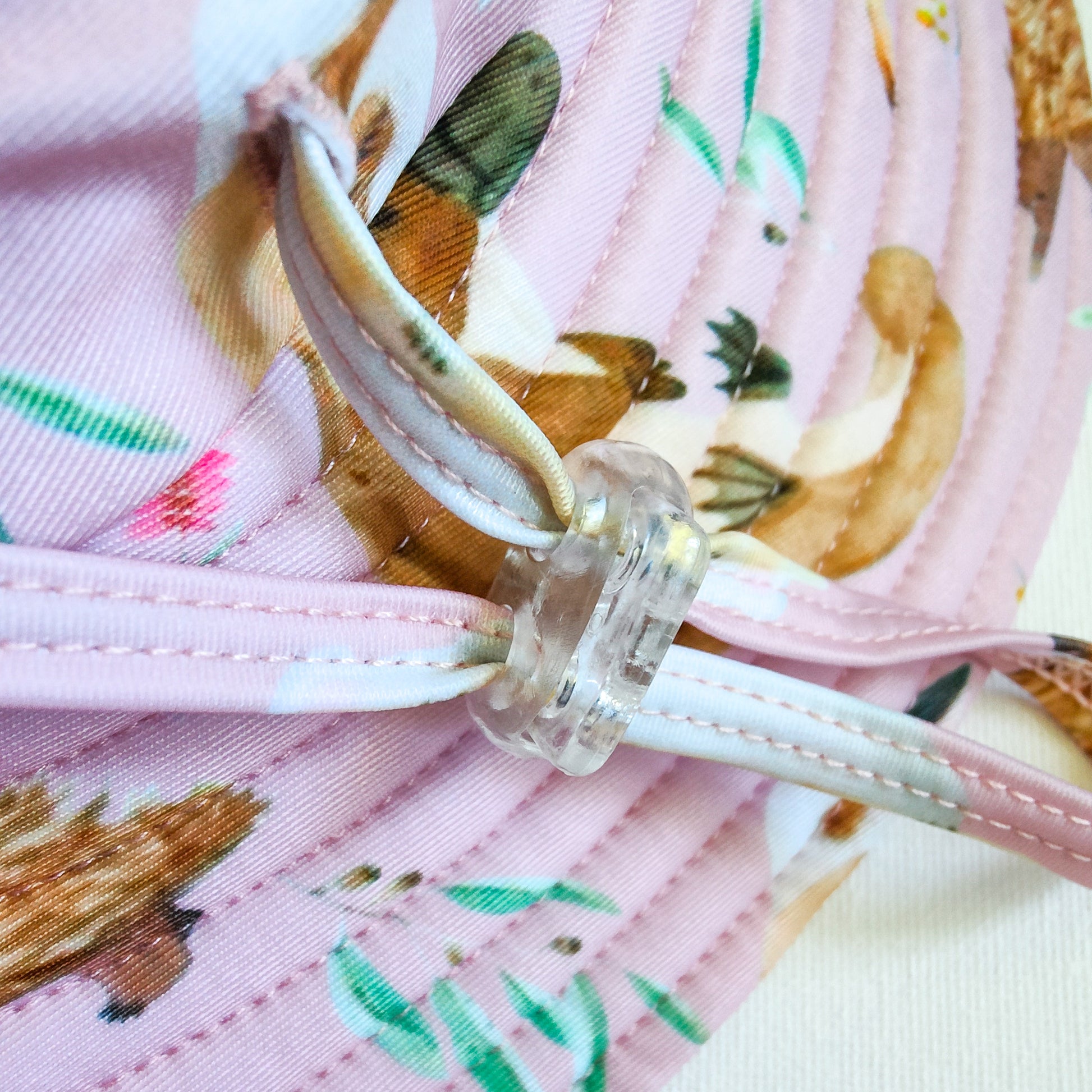 Kids swim hat in pale pink with colourful Australian animals print including koalas, kangaroos, platypus and echidnas. UPF 50+ fabric with adjustable toggles.