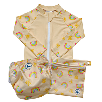 Baby swimwear set featuring a pale yellow long-sleeve rash guard, swim nappy with adjustable snaps, and wet bag with strap, all in a colourful rainbow and sun print.