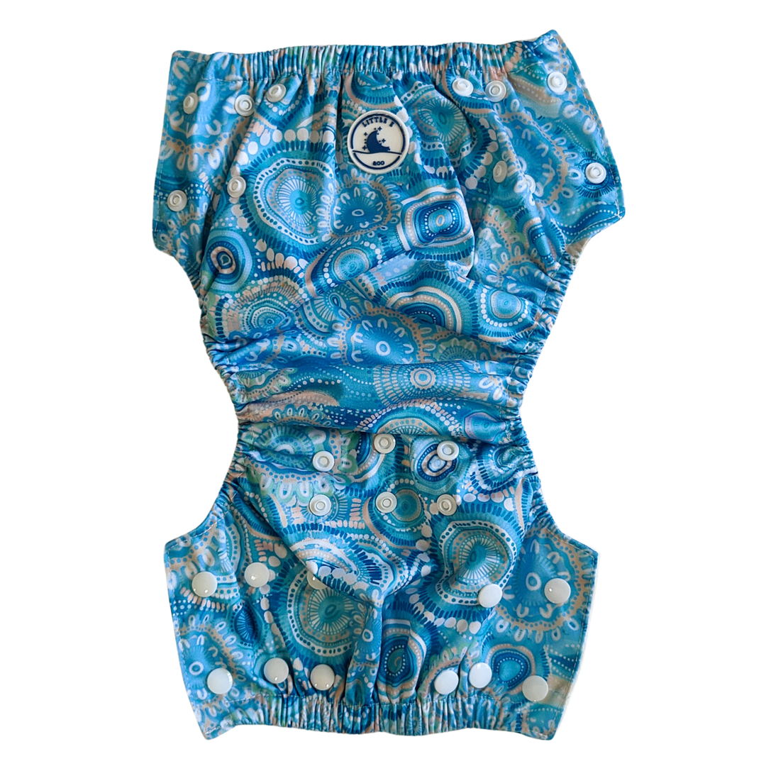 LITTLE E & CO – kids swim nappy, a turquoise blue with a colourful contemporary indigenous print. The swim nappy is a one size fits most design and has 3 adjustable snap settings.