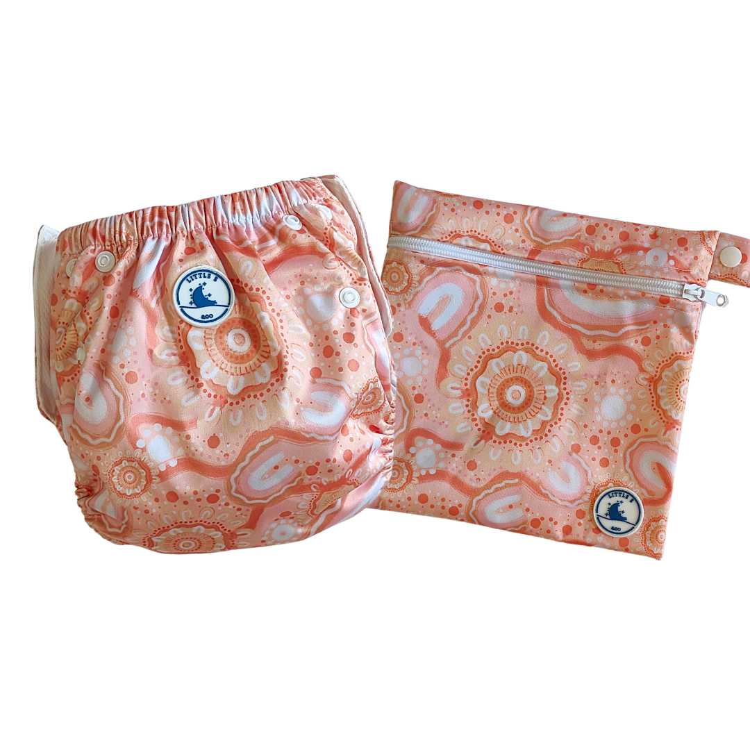 LITTLE E & CO – Two-piece kids' swim set, includes a swim nappy and wet bag, a peach pink with a colourful contemporary indigenous print. The swim nappy is a one size fits most design and has 3 adjustable snap settings and the wet bag has a strap.