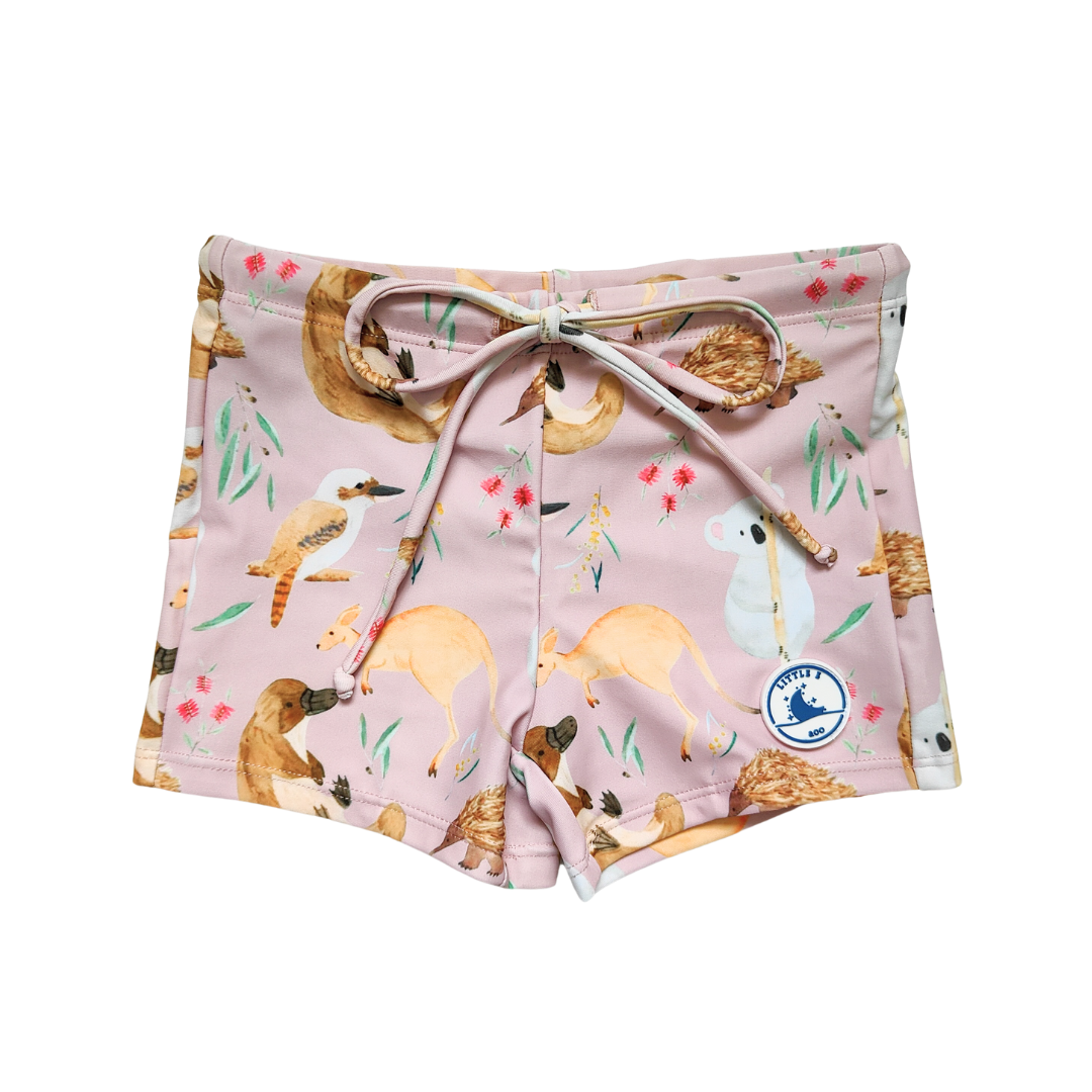 Kids swim shorts in pale pink with colourful Australian animals print, including koalas, kangaroos, and kookaburras, made with UPF 50+ fabric and adjustable drawstring waistband.