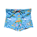 Kids Swim Shorts – Blue with a colourful ocean print featuring whales, turtles, fish, and coral. Made with UPF 50+ sun protection fabric. These swim shorts feature an adjustable drawstring waistband for a comfortable and secure fit—perfect for beach days and pool play.