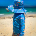 Baby Swimwear Set with ocean print worn by toddler, featuring long sleeve rashie with front zipper and matching swim hat with adjustable toggles.