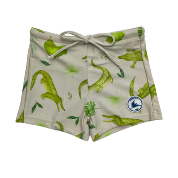 Beige shorts with green alligator pattern on a white background