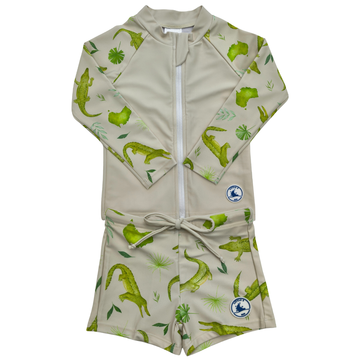 Children's swimsuit with green crocodile pattern on a beige background