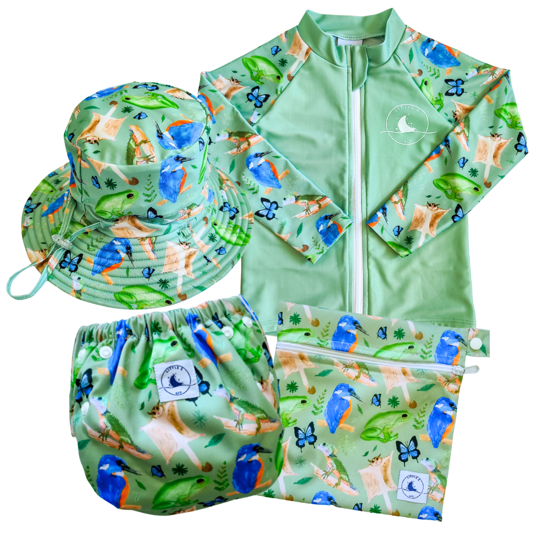 LITTLE E & CO - four-piece kids' swim set featuring a long-sleeve rash guard, swim hat, swim nappy and wet bag. The set is a green with a colourful rainforest print featuring birds, frogs, lizards and butterflies. Made with UPF 50+ sun protection fabric. The rash guard has a front zipper for easy wear, and the swim nappy has adjustable snaps, and the hat has adjustable toggles.