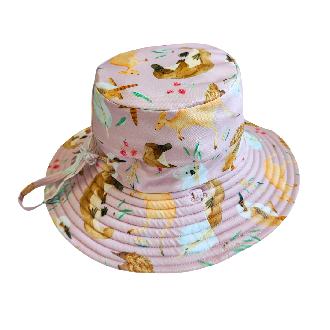 LITTLE E & CO – kids swim hat, a pale pink with a colourful Australian animals print featuring koalas, kangaroos, platypus, kookaburras and echidnas. Made with UPF 50+ sun protection fabric. The swim hat features adjustable toggles.