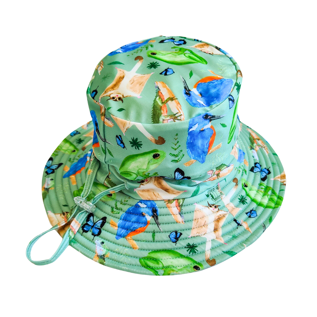 LITTLE E & CO – kids swim hat, a green with a colourful rainforest print featuring birds, frogs, lizards and butterflies. Made with UPF 50+ sun protection fabric. The swim hat features adjustable toggles.