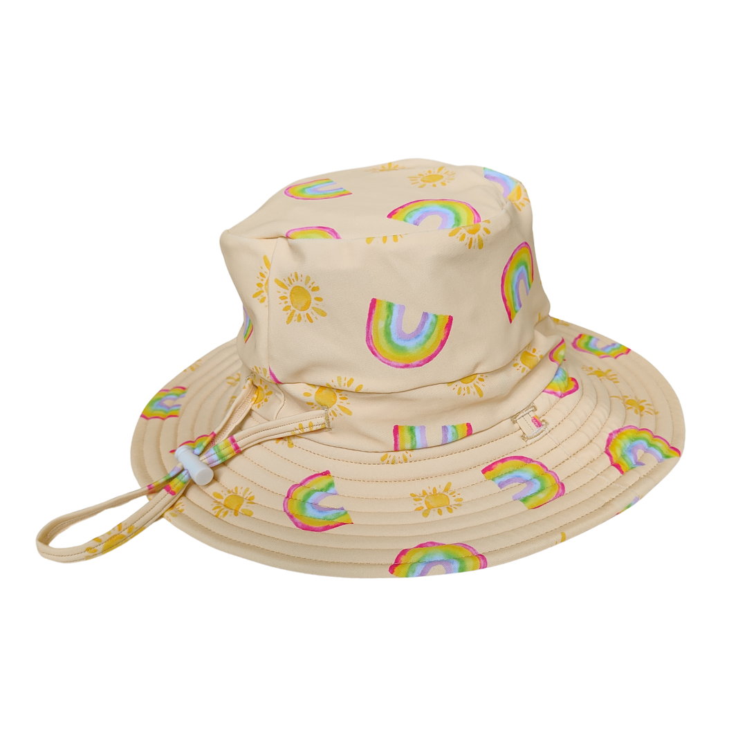 LITTLE E & CO – kids swim hat, a pale yellow with a colourful rainbow and sun print. Made with UPF 50+ sun protection fabric. The swim hat features adjustable toggles