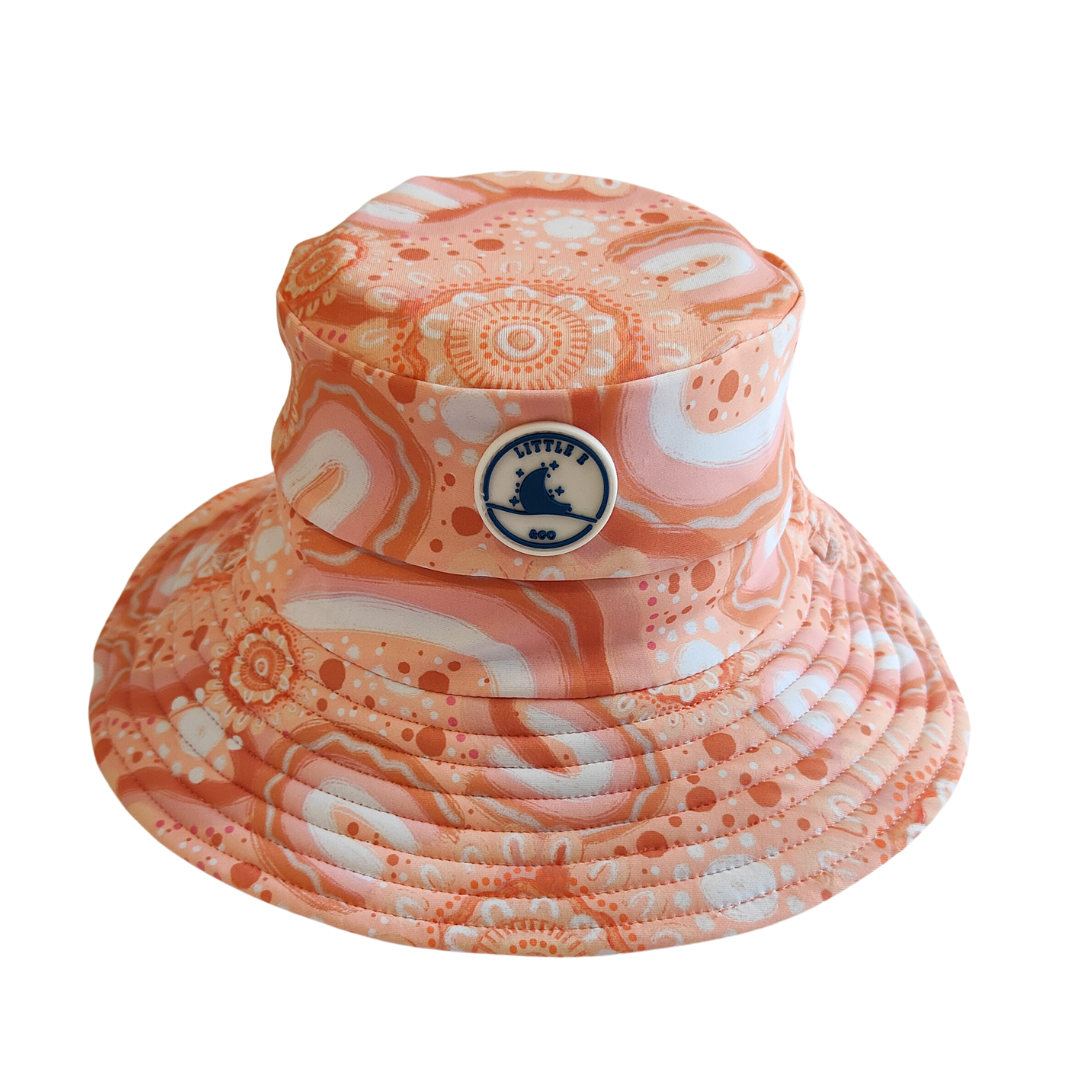 LITTLE E & CO – kids swim hat, a peach pink with a colourful contemporary indigenous print. Made with UPF 50+ sun protection fabric. The swim hat features adjustable toggles.