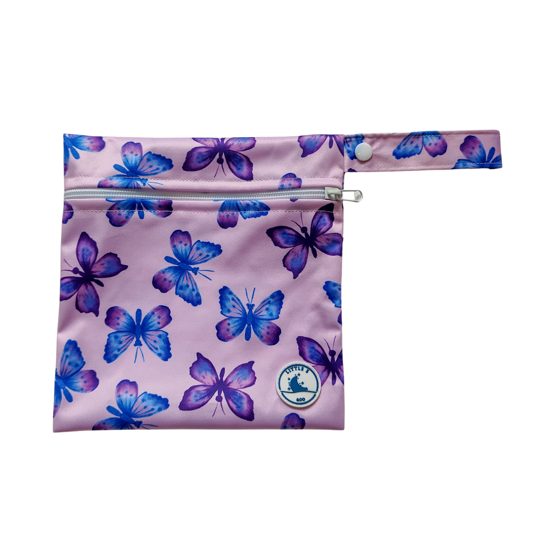 LITTLE E & CO – Mini wet bag, a pastel purple with a colourful pink, blue and purple butterflies. The wet bag is made from waterproof PUL and has a strap.