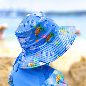 Baby Swimwear Set in ocean print with whales, turtles, fish, and coral, featuring UPF 50+ long sleeve rashie with front zipper and swim hat with adjustable toggles.

