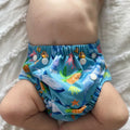 LITTLE E & CO – kids swim nappy, a blue with a colourful ocean print featuring whales, turtles, fish and coral. The swim nappy is a one size fits most design and has 3 adjustable snap settings.