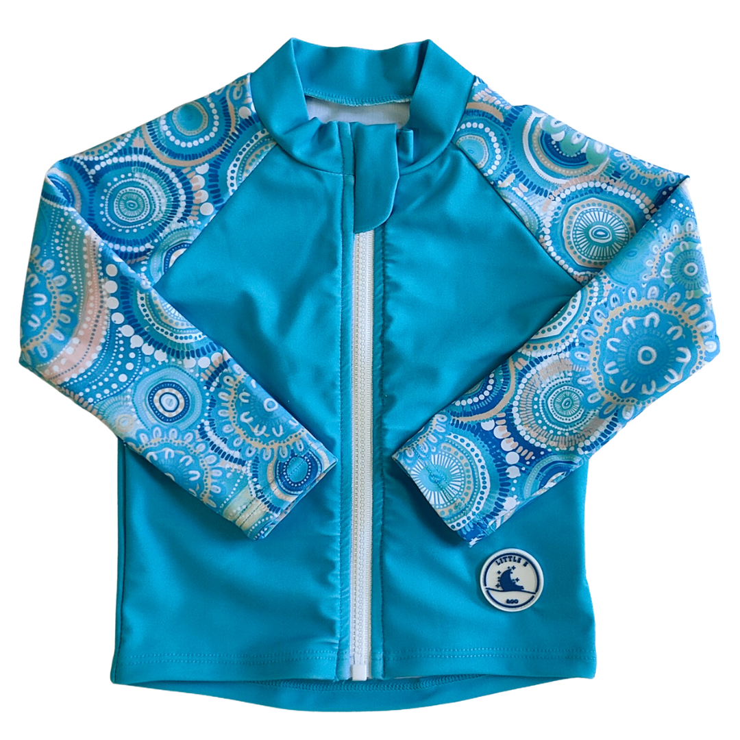 LITTLE E & CO – kids long-sleeve rash guard, a turquoise blue with a colourful contemporary indigenous print. Made with UPF 50+ sun protection fabric. The rash guard has a front zipper for easy wear.