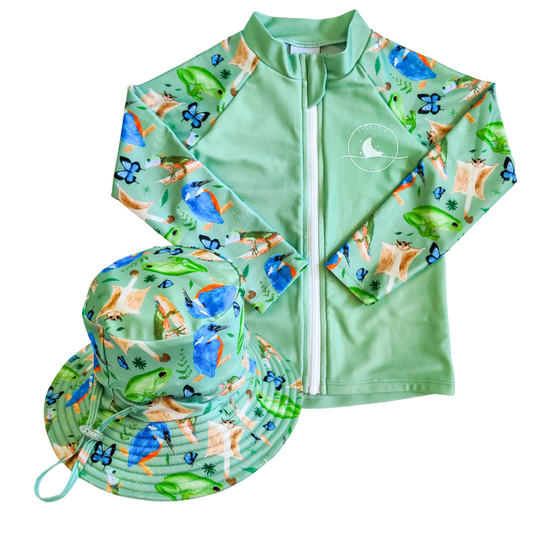 LITTLE E & CO - Two-piece kids' swim set featuring a long-sleeve rash guard and swim hat. The set is a green with a colourful rainforest print featuring birds, frogs, lizards and butterflies. Made with UPF 50+ sun protection fabric. The rash guard has a front zipper for easy wear, and the hat features adjustable toggles.