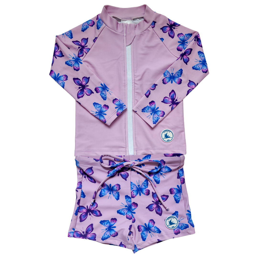 LITTLE E & CO - Two-piece kids' swim set featuring a long-sleeve rash guard and swim shorts. The set is a pastel purple with a colourful pink, blue and purple butterflies. Made with UPF 50+ sun protection fabric. The rash guard has a front zipper for easy wear, and the shorts feature an adjustable drawstring waistband for a secure fit. 