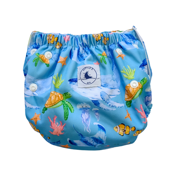 Reusable swim nappy in Ocean print, a blue design featuring whales, turtles, fish and coral