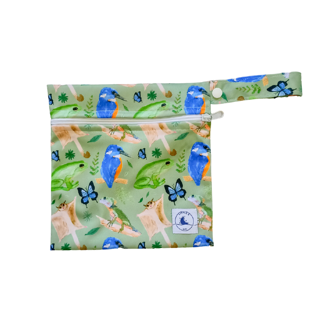 LITTLE E & CO – Mini wet bag, a green with a colourful rainforest print featuring birds, frogs, lizards and butterflies. The wet bag is made from waterproof PUL and has a strap.